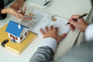 Real estate agents agree to buy a home and give keys to clients at their agency's offices. Concept agreement photo