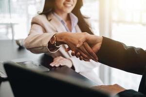 Close up of asian business people shaking hand, finishing up meeting, business etiquette, congratulation, merger and acquisition concept. photo