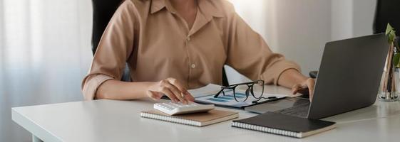 Accountant businesswoman working with calculator for financial document in office. male accountant doing accounting and calculating. bookkeeper making calculation. Savings, finance. photo