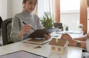 Real estate agent or bank officer describes the loan interest to the customer with home purchase contracts or on office loans and interest rates, selective focus photo