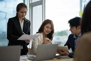 Diverse business workgroup designers team with asian woman leader discuss paperwork financial report statistical data, forecasting working on common project. Brainstorm, briefing activity concept photo