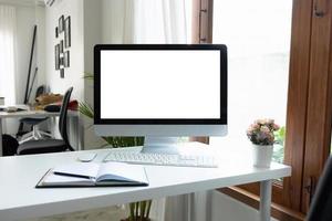 Blank screen desktop computer in office room with decorations and copy space photo