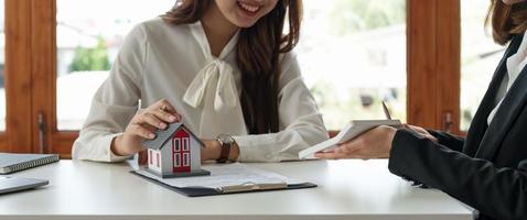 Real estate agent or bank officer describes the loan interest to the customer with home purchase contracts or on office loans and interest rates photo