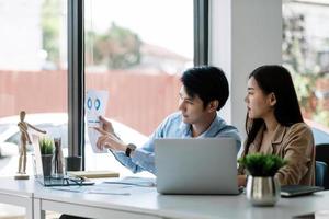 Two business asian data dashboard analysis. Investment application display business sales and profit on paperwork and advise marketing planning decision. photo
