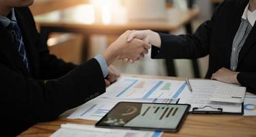 Two business people shake hands after accepting a business proposal together, a handshake is a universal homage, often used in greeting or congratulations. photo