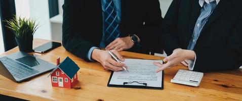 Experienced real estate agent showing house model to client and ready to sign contract photo