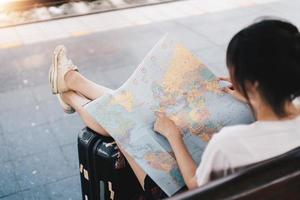 Back side of traveler girl searching right direction on map, traveling along asian by train, freedom and active lifestyle concept photo