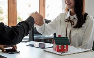 Estate agent and customer shaking hands after fafter signing contract about home insurance and investment loan. photo