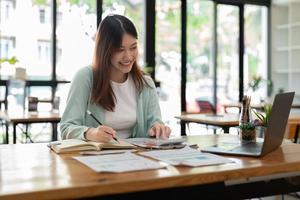 Business accountant woman using calculator for do math finance on wooden desk in office and business working background, tax, accounting, statistics and analytic research concept photo