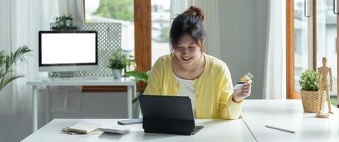 Close up of girl hold bank credit card, shopping online using laptop computer, buying goods or ordering online, entering bank accounts and details in online banking offer. photo