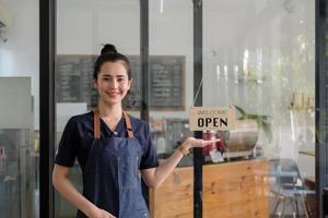 retrato de una mujer asiática sonriente que inicia una exitosa pequeña empresa en un restaurante cafetería. dueña de una cafetería barista. pyme empresario vendedor concepto de negocio foto