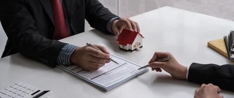 Businessman and estate agent signing a document for house deal photo