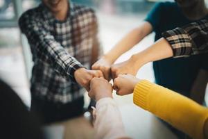 diverse group of asian business partner fist bump in modern office. Colleague partnership teamwork, university student, congratulation event, job or mission accomplish concept photo