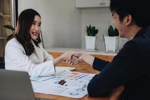 Negotiating business,Image of businesswomen Handshaking, Business people shaking hands, finishing up meeting, business etiquette, congratulation, merger and acquisition concept photo