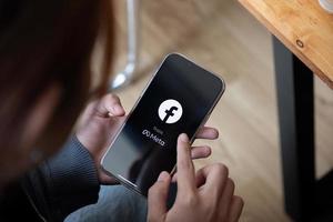 A woman holds Apple iPhone 13 with facebook logo on the screen from meta. Facebook is a largest social network and most popular social networking site in the world photo