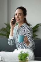 Attractive asian businesswoman talking on mobile phone with client. photo