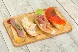 Tapas - bruschetta with prosciutto, salmon, duck and gorgonzola photo