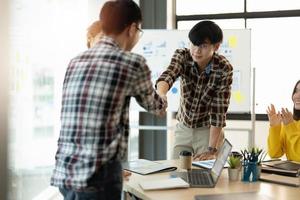 Happy asian business people shaking hands in meeting room photo