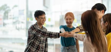 diverse group of asian business partner fist bump in modern office. Colleague partnership teamwork, university student, congratulation event, job or mission accomplish concept photo