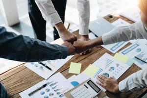 grupo diverso de socios comerciales asiáticos golpean el puño en la oficina moderna. trabajo en equipo de la asociación de colegas, estudiante universitario, evento de felicitación, concepto de trabajo o misión foto