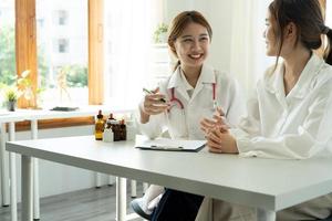 Young asian doctor talking with her patient life insurance policy photo
