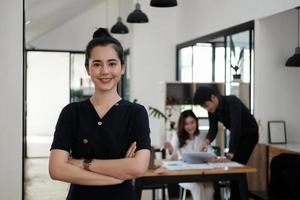 Confident of beautiful asian businesswoman standing in office arms crossed photo