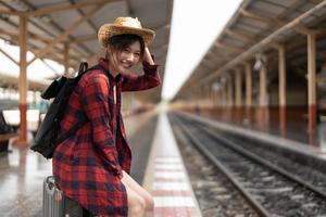 Happy asia woman traveller feeling happiness before go to travel at the train station, summer travel and lifestyle concept photo