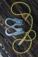 Modern style. Isolated photo of climbing equipment. Parts of carabiners lying on the wooden table