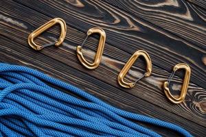 View from the top. Isolated photo of climbing equipment. Part of carabiner lying on the wooden table