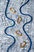 Looks like river. Isolated photo of climbing equipment. Part of carabiner lying on the white and grey colored table