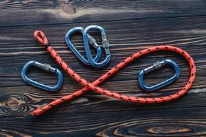 Conception of extreme sports. Isolated photo of climbing equipment. Part of carabiner lying on the wooden table