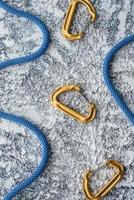 Snap hooks. Isolated photo of climbing equipment. Part of carabiner lying on the white and grey colored table