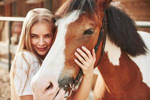 Her lucky horse. Happy woman on the ranch at daytime photo