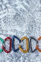 Green, red and other colors. Isolated photo of climbing equipment. Part of carabiner lying on the white and grey colored surface