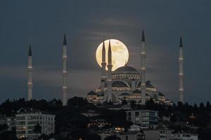 Moonrise over Camlica Mosque in Istanbul, Turkey photo