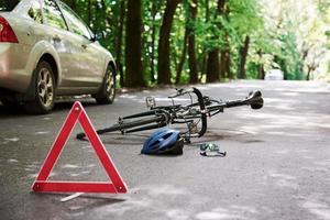 Help is on the way. Bicycle and silver colored car accident on the road at forest at daytime photo