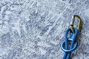 vista de partículas foto aislada del equipo de escalada. parte del mosquetón sobre la superficie de color blanco y gris