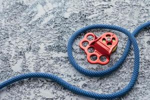 Hiking rope. Isolated photo of climbing equipment. Part of carabiner lying on the white and grey colored table