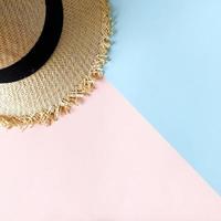 Woven hat on pastel pink and blue color background summer photo