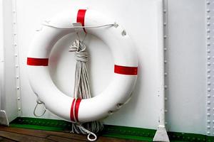 aro salvavidas rojo blanco y barco blanco foto