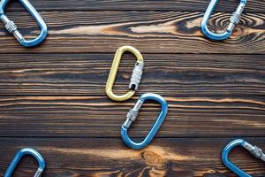 Yellow and blue colored. Isolated photo of climbing equipment. Parts of carabiners lying on the wooden table