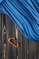 Many of long cable. Isolated photo of climbing equipment. Part of carabiner lying on the wooden table