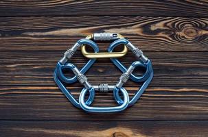 Circle of objects. Isolated photo of climbing equipment. Parts of carabiners lying on the wooden table