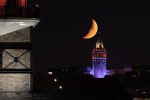 puesta de la luna sobre la torre de galata en estambul, turquía