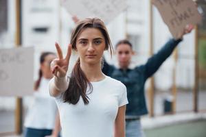 Friends at background. Group of feminist women have protest for their rights outdoors photo