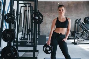 Many of equipment. Photo of gorgeous blonde woman in the gym at her weekend time