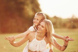 Beautiful nature. Mother and daughter enjoying weekend together by walking outdoors in the field photo