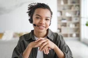 Virtual assistant. Young afro woman in headset is operator of client support service from home. photo