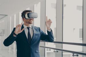 Handsome smiling businessman in vr headset using innovative technologies for business at work photo