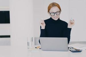 Confident female entrepreneur woman in office is doing paperwork with marker pen highlighting text. photo